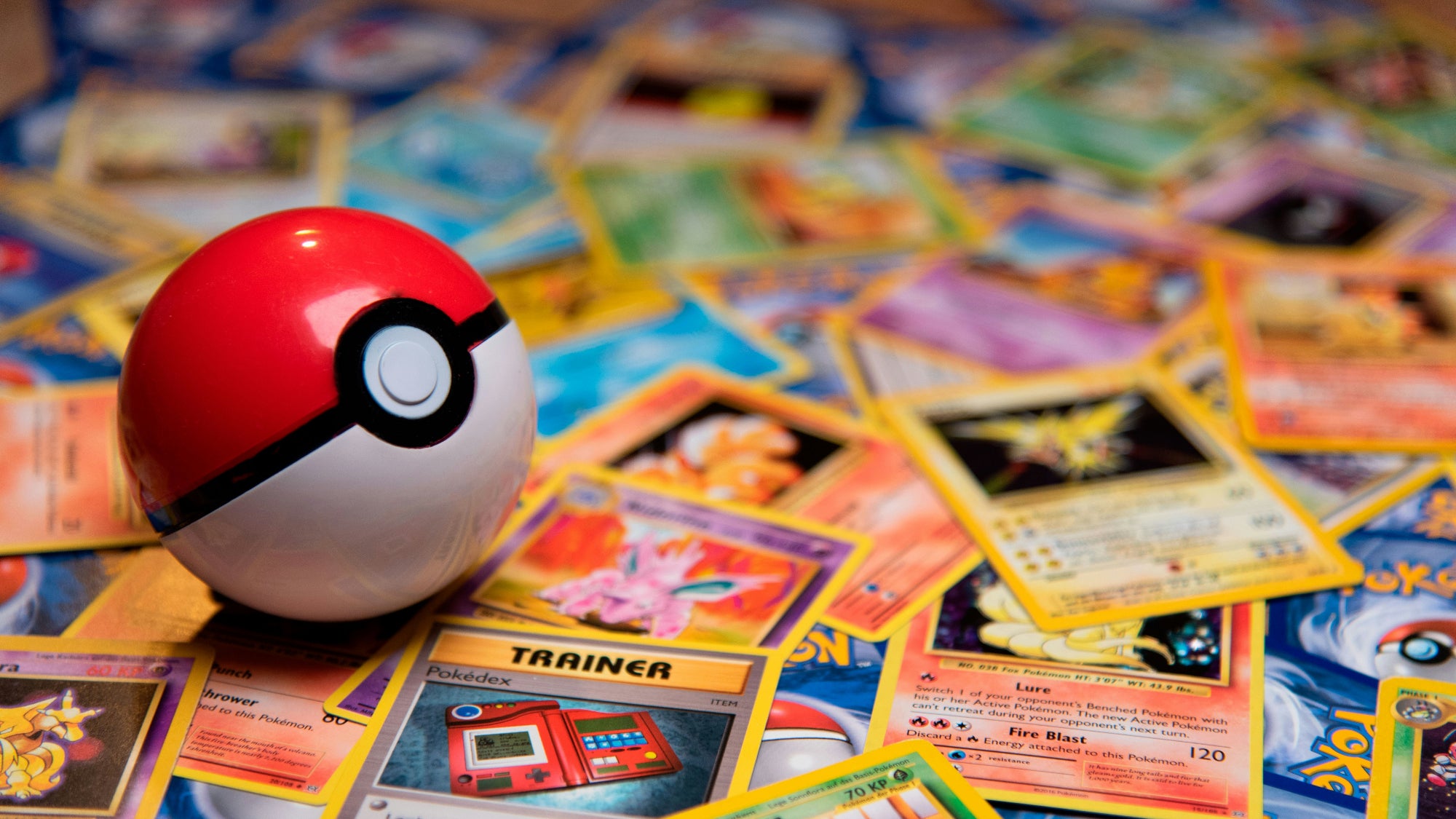 Poké Ball on top of colorful trading cards